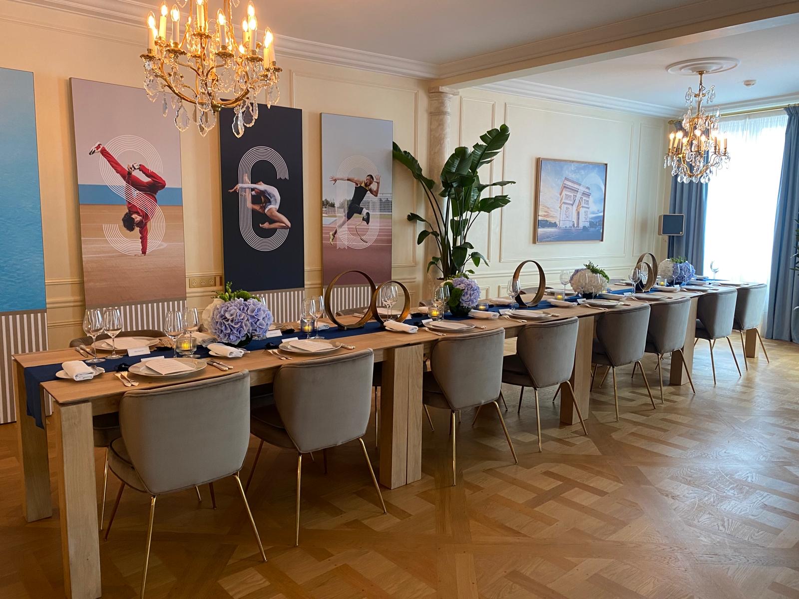 Long dinner table set with plates, cups and silverware in Cisco Olympics Lounge